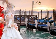 Femmes déguisées en rouge et blanc pour le Carnaval de Venise proches de gondoles 