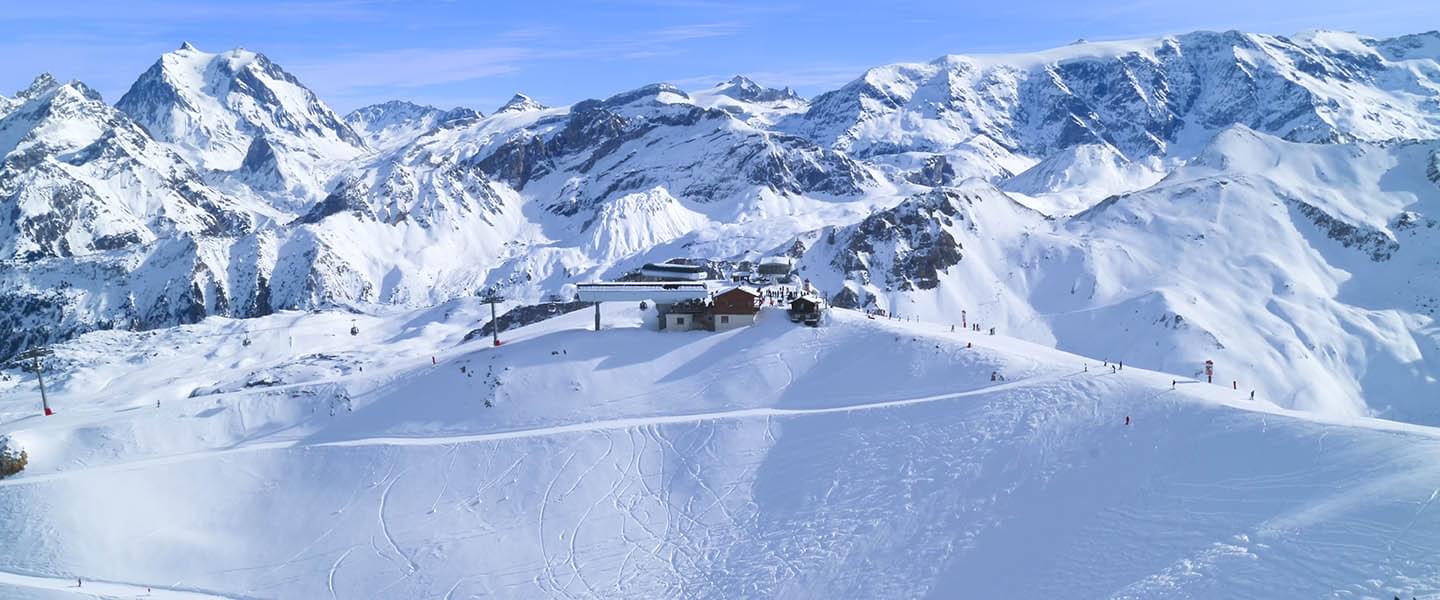 Вид на заснеженные горы Куршевеля с подъезжающим подъемником, ведущим к трассам