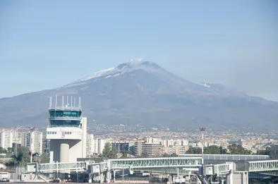 Photo de l'Aéroport Catane-Fontanarossa, sa tour de contrôle élégante avec l'imposant volcan Etna en toile de fond.