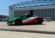 Coche Lamborghini con bandera italiana en el Valle del Motor de Bolonia