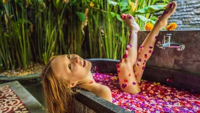 Une femme d'affaires se détend dans une piscine et prend un bain de fleurs