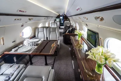 Das Innere eines geräumigen Privatjets, mit Blumen und Esstischen