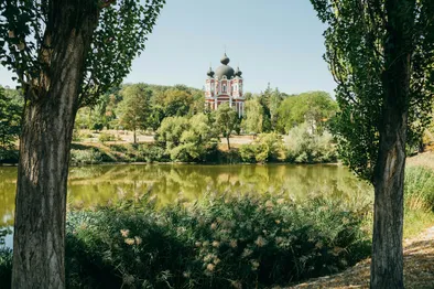 Vue paisible du Monastère de Curchi à Orhei, entouré de nature verdoyante et d'un lac.