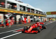 Red Ferrari formula one racing car during the Italian F1 Grand Prix in sunlight