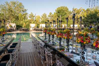 Table joliment décorée avec des fleurs et piscine en arrière plan au Bilkent Hotel