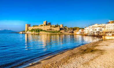 The iconic Bodrum Castle looms majestically over the beach, a defining feature of Bodrum's captivating landscape, a favourite among private jet travellers and a top tourist hotspot in Turkey.