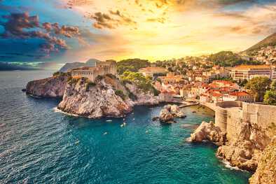 A stunning sunset over Dubrovnik, Croatia, showcasing the city's ancient fortifications and crystal-clear Adriatic Sea, a top destination for private jet travellers.