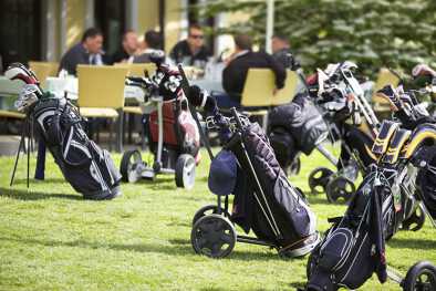 Golf caddies and clubs parked outside a golf club restaurant